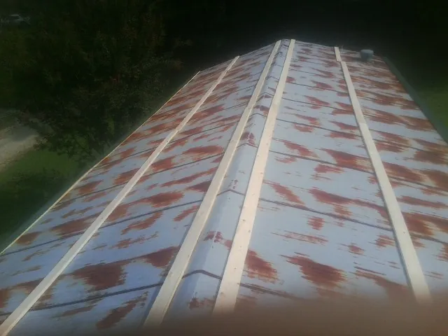 Rusted metal roof panels with new wood purlins before replacement — Storm Damage Roof Repair in Addison by Roofing Brothers